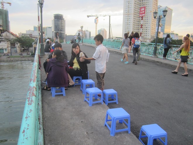 Hàng chục ghế nhựa được những người bán hàng rong bày trên mặt cầu, làm chỗ ngồi cho khách.