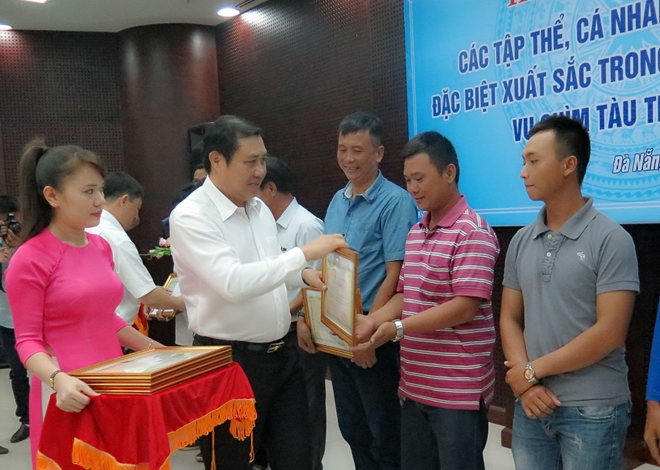 Chủ tịch UBND TP.Đà Nẵng trao Bằng khen choLê Văn Hoa (phải) và những gương sáng tham gia cứu các du khách bị nạn. Ảnh: CAND