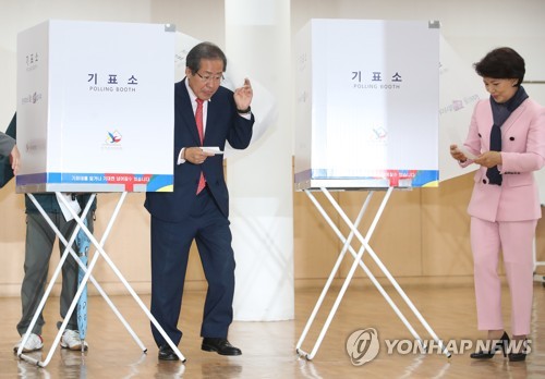 Ứng viên Hong Joon Pyo và vợ đang bỏ phiếu bầu cử tại một địa điểm bỏ phiếu ở phía nam Seoul ngày 9.5. Ảnh: Yonhap