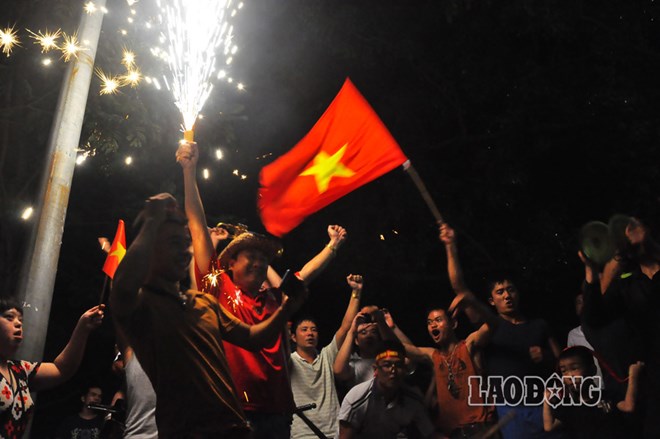 Thỉnh thoảng pháo sáng lại bừng lên trong màn đêm, Hà Nội như một ngày hội của người hâm mộ bóng đá Việt Nam.