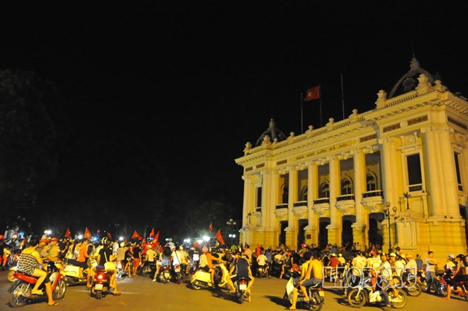 Hàng nghìn chiếc xe được di chuyển trên khắp các tuyến phố Hà Nội ăn mừng ngày các cổ động viên Việt Nam tìm lại được tình yêu với đội tuyển bóng đá Việt Nam. Ảnh chụp tại Nhà hát lớn Hà Nội.